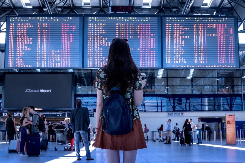 Personne regardant un panneau de vols à l'aéroport