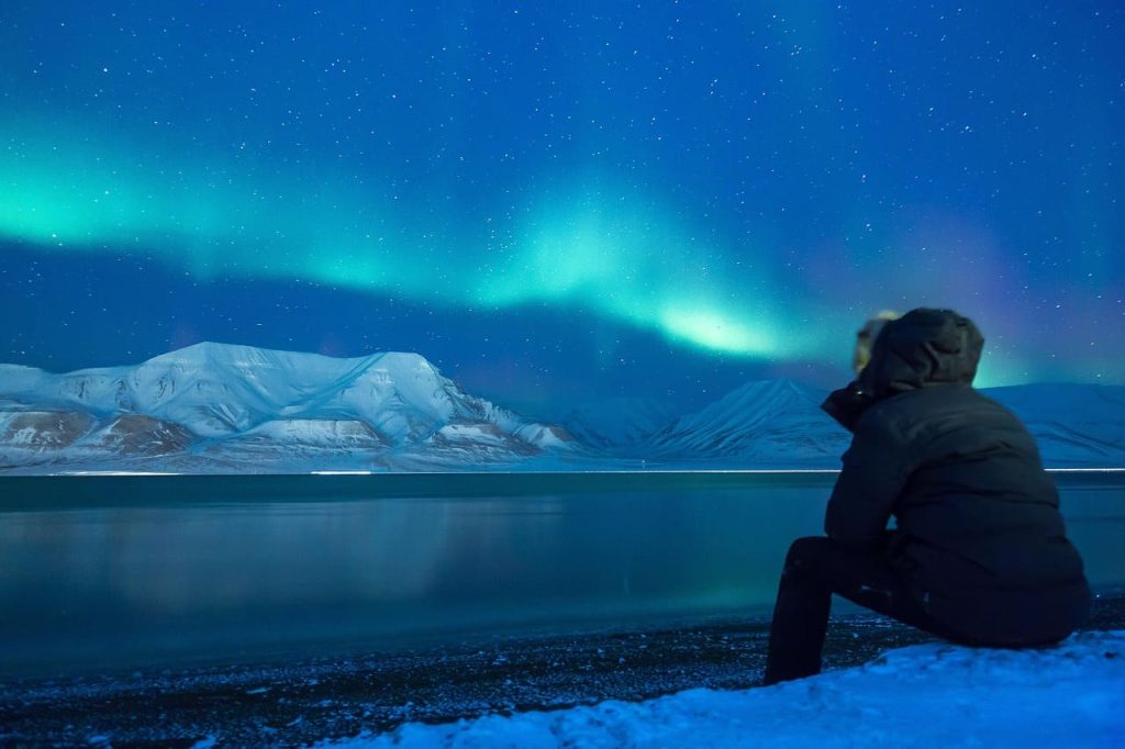 Aurores boréales au-dessus des montagnes enneigées à Tromsø en Norvège
